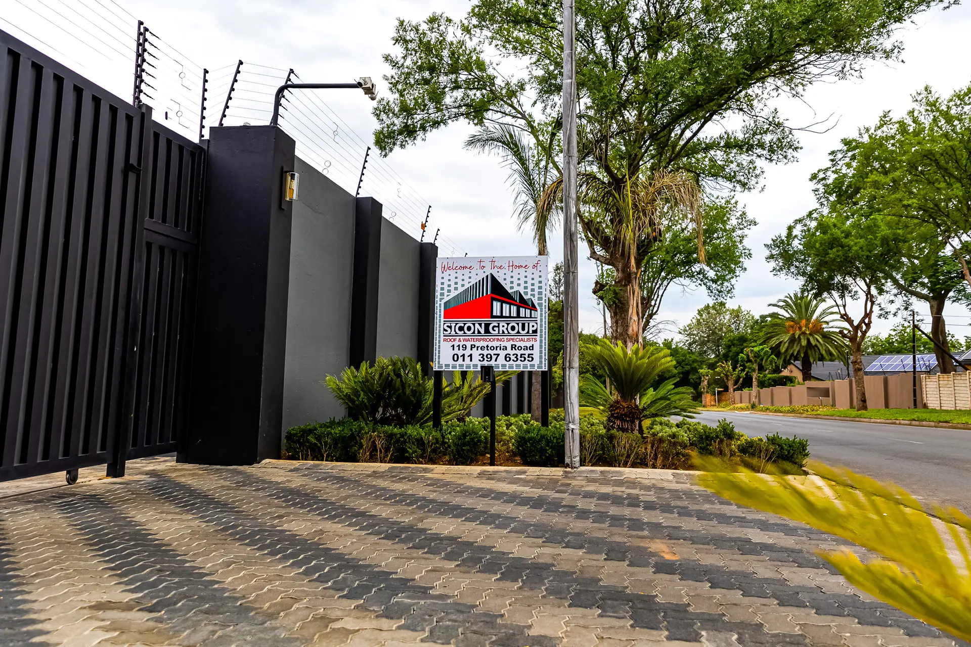 View of Sicon Group's secured entrance gate and sign, offering expert commercial roofing services near me at 119 Pretoria Road.